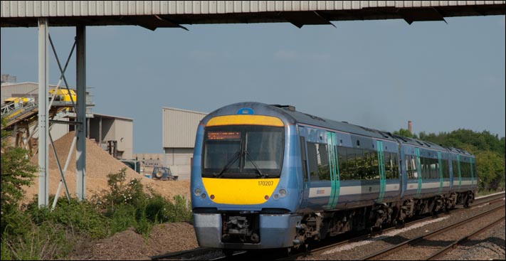 At the road crossing at Funthams Lane at Kings Dyke is National Express East Anglia class 170207 heading for Peterborough in 2010.