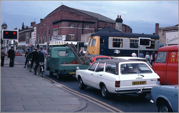 Traffic waits at the St Marks station level crossing  over  the  High  Street  in  Lincoln  in  1978.  