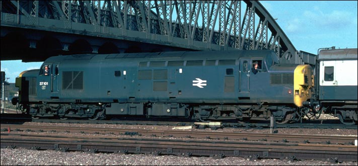 Class 37 101 is coming out of platform 4 or 5 and is propelling its train from the rear into the carriage sidings.