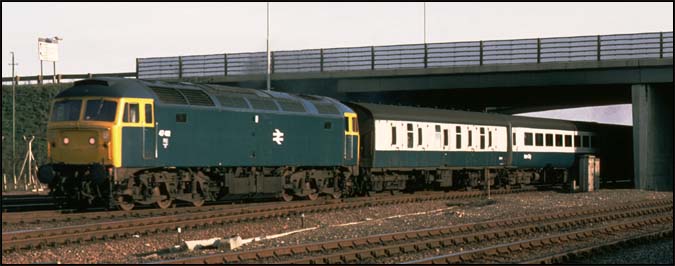 A class 47 on a down train comes under the A47 road bridge at Walton on the ECML