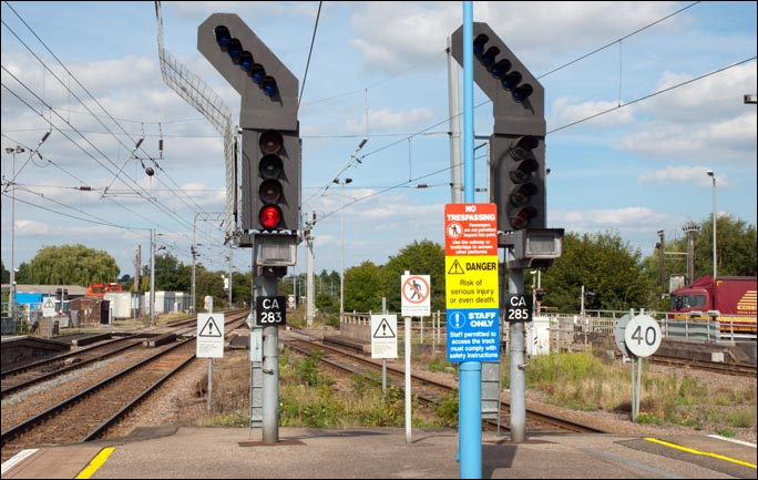 Two of the signals and signs at the north end of Ely station in 2013
