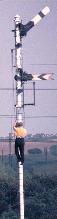 A man is up one of the signals just south of Wellingborough station changing the lamps A man is up one of the signals just south of Wellingborough station changing the lamps